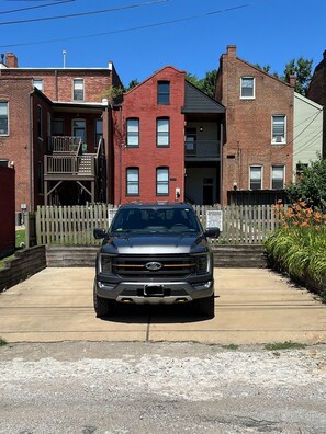 A Ford truck parked in front of a brick building with a wooden fence and a sign warning against parking. - Brand New! Soulard Charmer - Pet Friendly.  (St. Louis)