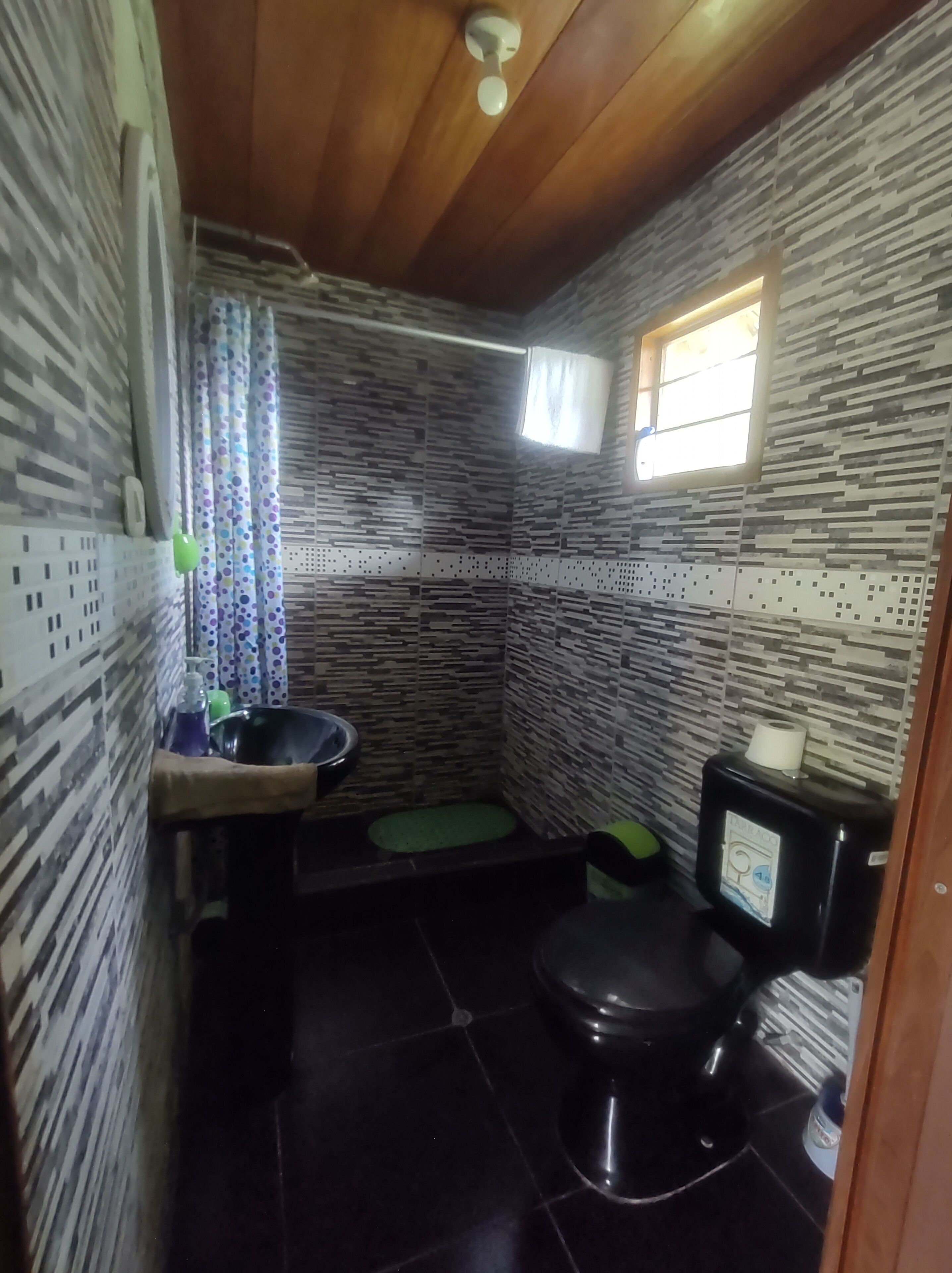 A compact bathroom with a toilet, sink, and shower area.