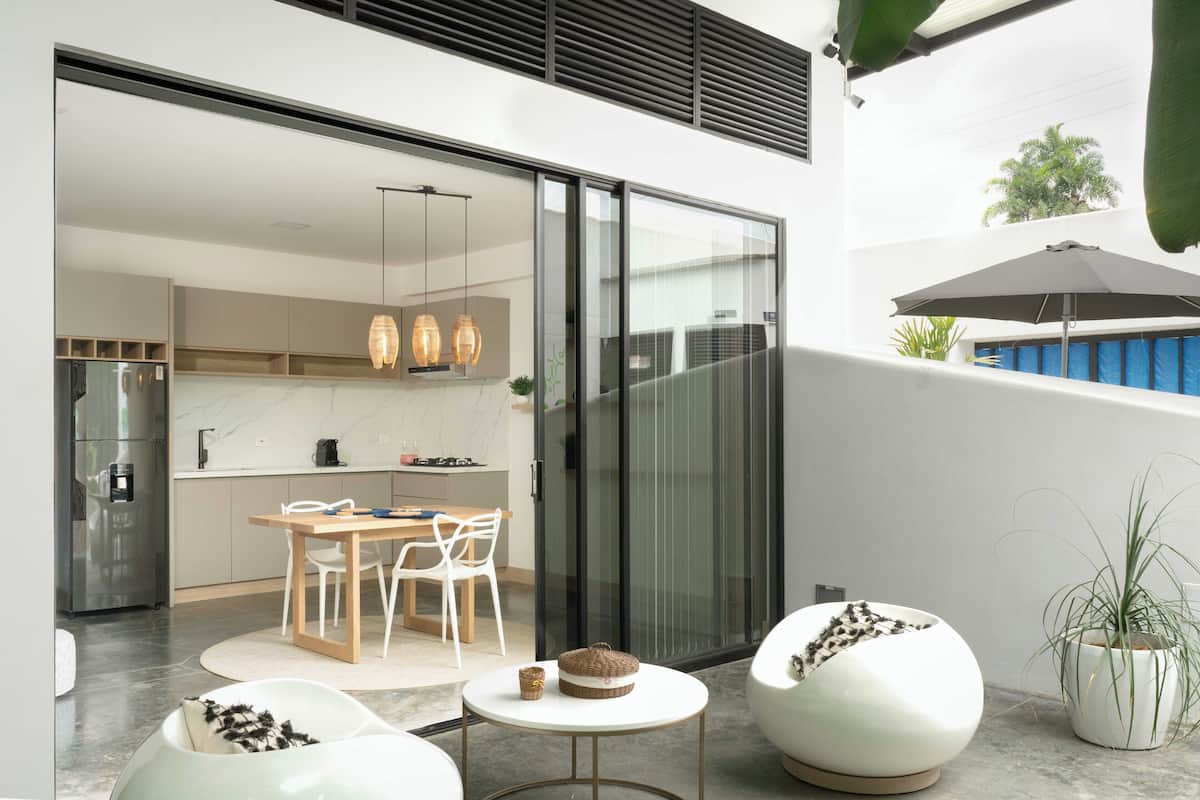 Eine moderne Küche mit Essbereich, einer Schiebetür zum Balkon und einem Blumentopf.