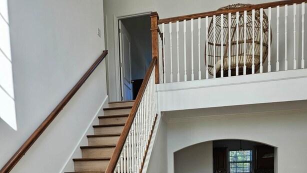 A spacious interior with a wooden staircase leading to a second floor. - Spacious 4-bedroom home in private nature (Moore)