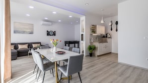 Een moderne woonruimte met een eethoek, keuken en een zithoek.