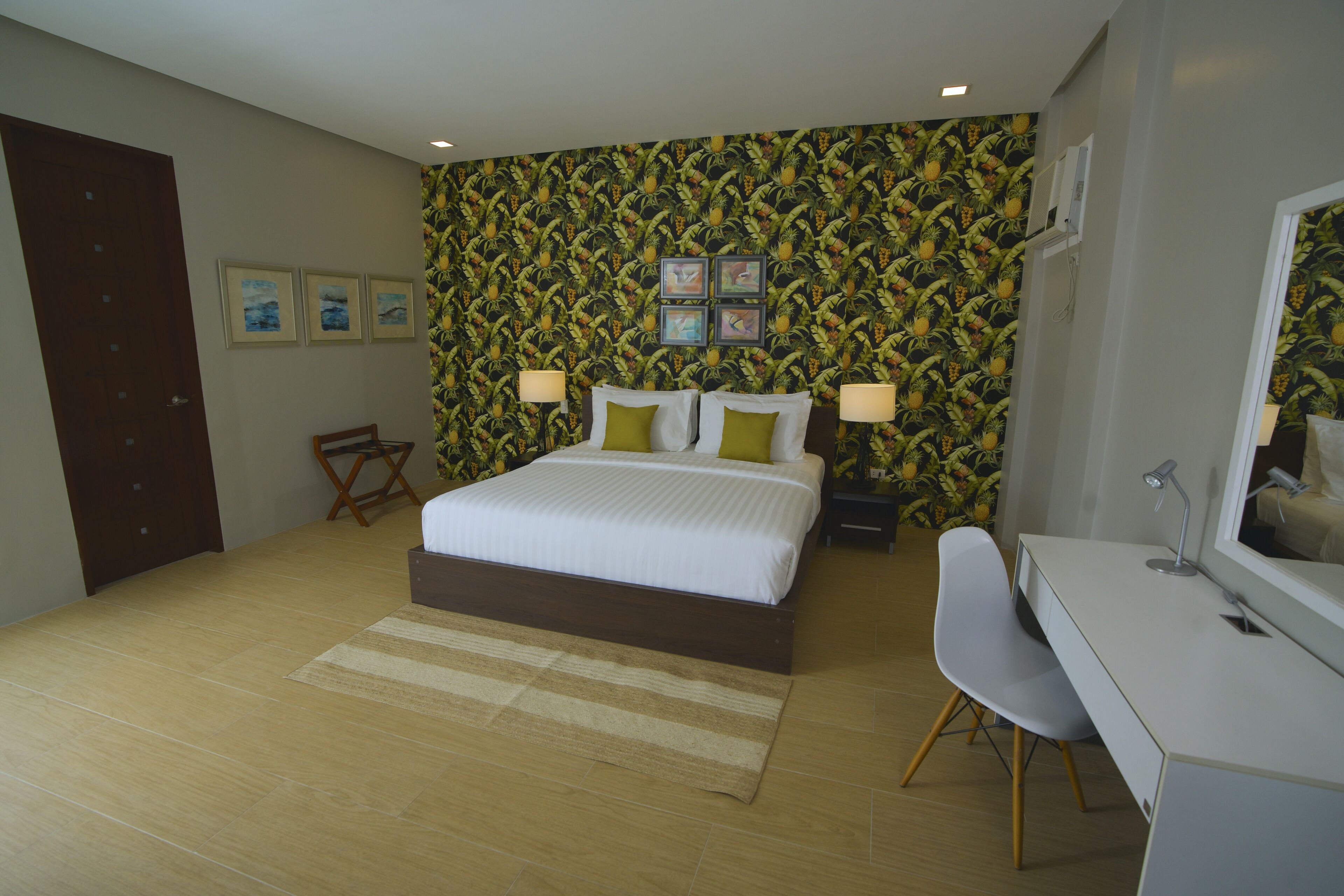 A bedroom with a bed, bedside tables, a desk, and a chair.