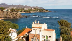 A coastal town with buildings along the shoreline, a clear view of the sea, and mountains in the background. - Apartment Faner by Interhome (Llançà)