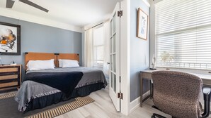 A bedroom with a bed, bedside table, and a desk with a chair. - Executive-next to Convention Center + Free Parking (Long Beach)