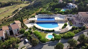 An aerial view of a resort with a large central pool, multiple buildings, and surrounding greenery. - Apartment Apj03 - Anesi (Kouklia)
