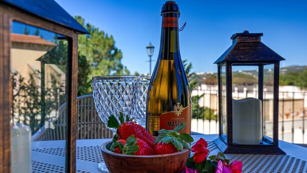 A bottle of Cantina Maschio wine, a glass, and a bowl of strawberries on an outdoor table. - Apartment Apj03 - Anesi (Kouklia)