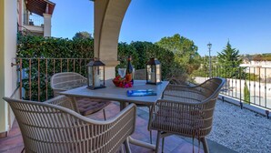 An outdoor patio with a table, chairs, and decorative items.