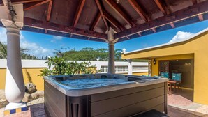 A hot tub under a wooden pergola with a clear blue sky in the background. - NEW Casa Kudawecha (Noord)