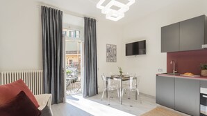 Un appartement moderne comprenant un coin repas, une cuisine et offrant une vue sur l’extérieur.