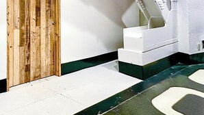 Una scala con una porta in legno e pareti bianche.