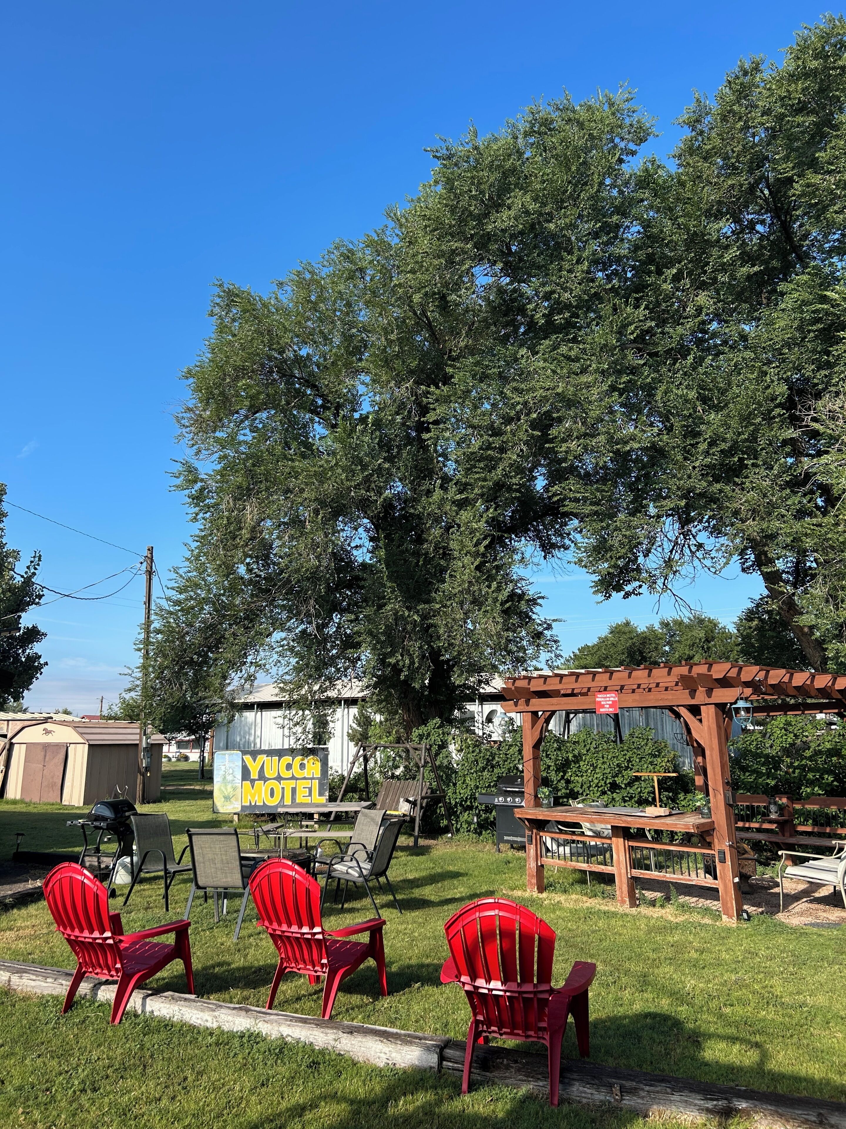 Ein Yuca Motel mit Außenbereich, Grillmöglichkeit und einer Pergola.