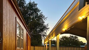 A wooden house with a stone pathway leading to a covered porch with lights. - The Lodge at Ute Lake (Logan)