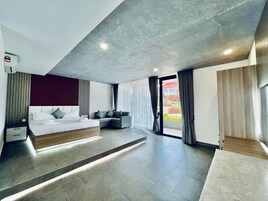 Une chambre moderne avec un lit, un canapé et des rangements intégrés.