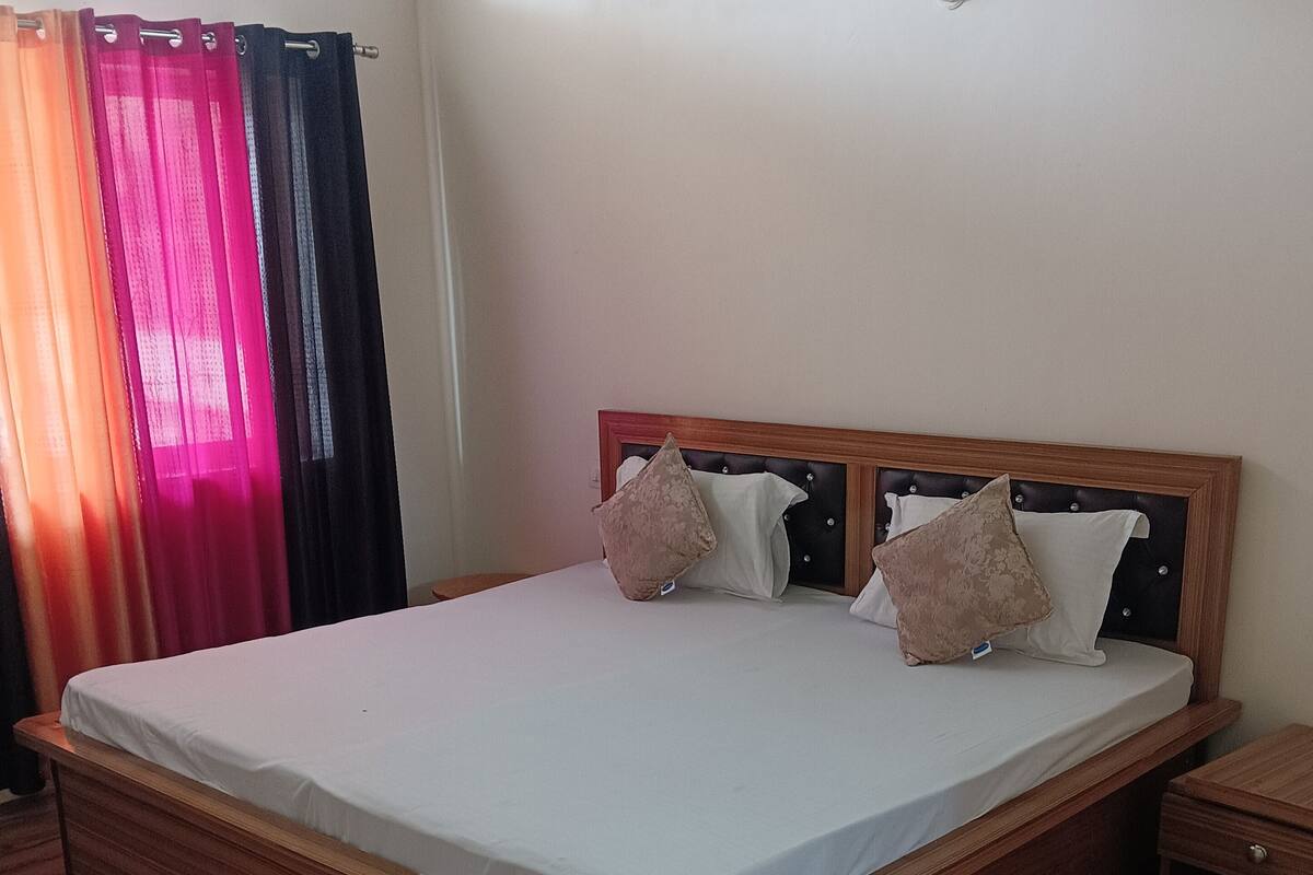 A neatly made bed with a wooden frame and a headboard, accompanied by two bedside tables.