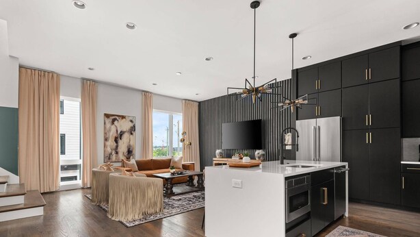 A modern kitchen with black cabinets, a stainless steel refrigerator, and a central island. - Howdy Honey! 8 Beds ~ Hot Tub with Double Deck Rooftop & Amazing City Views  ~ 3 Miles to Broadway! (Nashville)