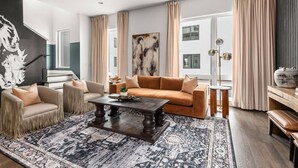 A spacious living room with a large sofa, a coffee table, and a patterned rug. - Howdy Honey! 8 Beds ~ Hot Tub with Double Deck Rooftop & Amazing City Views  ~ 3 Miles to Broadway! (Nashville)