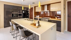A modern kitchen with a large island, stainless steel appliances, and pendant lighting. - Stylish 2BR House for a Memorable Stay @Stretton (Stretton)