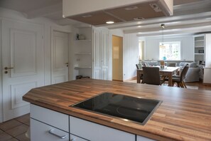 Eine moderne Küche mit einer Holz Arbeitsplatte, integrierten Schränken und einer Kochinsel in der Mitte.