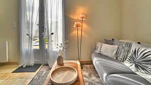 A living room with a sofa, a coffee table, a floor lamp, and a decorative vase. - Les Pâquerettes by Interhome (Ile d'Oléron)