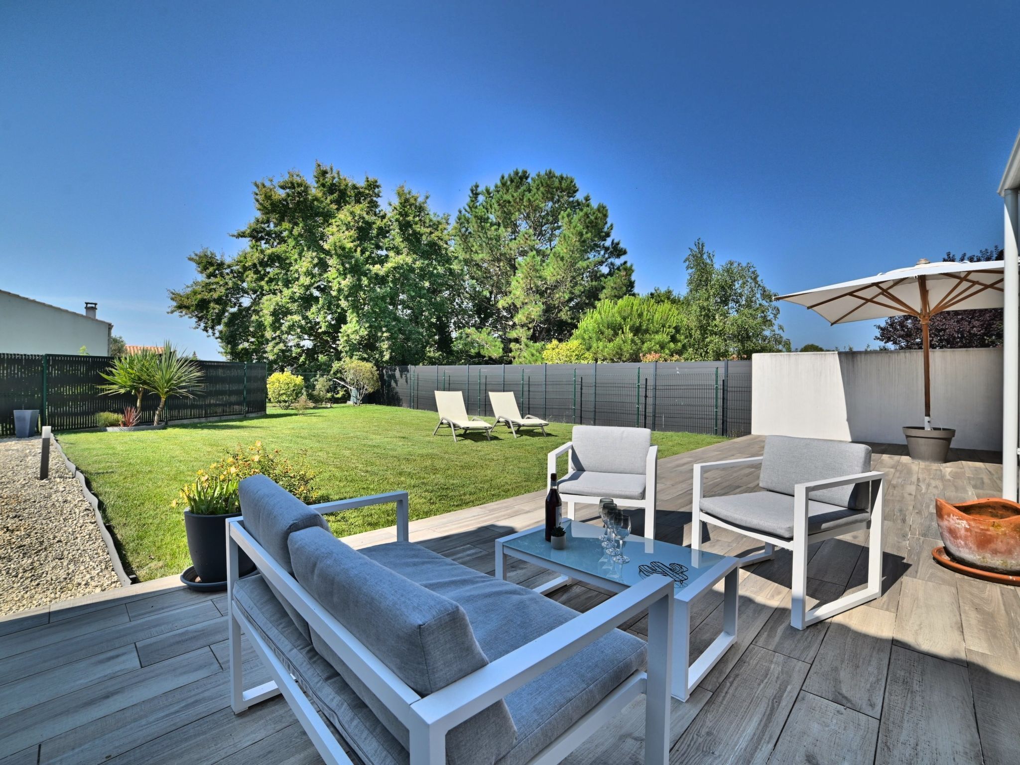Eine Terrasse mit einer Couch, Stühlen und einem Tisch.