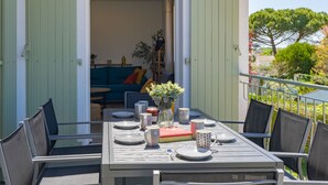 An outdoor dining area with a table set for four, surrounded by chairs.