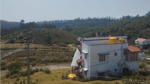 A building with a flat roof, two yellow water tanks, and a red and white striped awning.