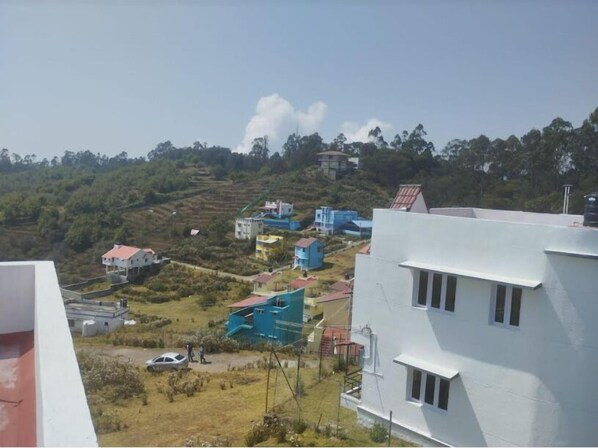 A residential area with houses on a hillside, surrounded by greenery. - STARLIGHT HOTELS KODAI (Kodaikanal)