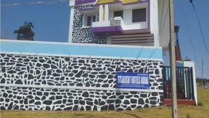A hotel with a distinctive facade featuring a stone-patterned wall and a colorful upper section with purple and yellow accents.