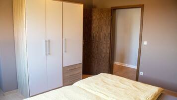 A bedroom with a bed, wardrobe, and a mirror.