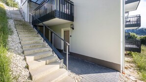 Portaat johtavat parvekkeelliseen rakennukseen, jossa on ovi ja päällystetty alue.