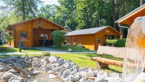 A wooden cabin with a patio, surrounded by a natural landscape. - Holiday Home 'Ferienhaus 5 Familie Täubert' with Private Terrace, Private Garden and Wi-Fi (Boxberg/Oberlausitz)