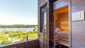 A sauna with a wooden exterior, a window, and a view of a lake. - Apartment "Seen-Sucht" with Lake View, Shared Garden & Wi-Fi (Bad Endorf)