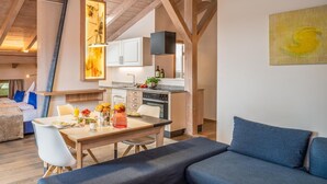 A modern interior with a dining area, kitchen, and a sofa. - Apartment "Ambiente" with Lake View, Shared Garden & Wi-Fi (Bad Endorf)