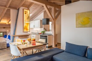 Un interior moderno con comedor, cocina y sofá.