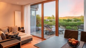 A modern bedroom with a large sliding glass door leading to a patio with outdoor furniture. - Apartment "Wellvital" with Private Terrace & Wi-Fi (Bad Endorf)