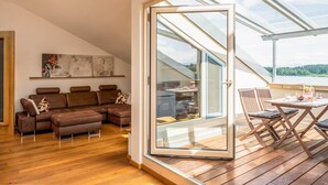Un salon moderne doté d’une porte coulissante en verre donnant sur un patio extérieur.