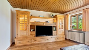 A wooden entertainment unit with a flat-screen TV, drawers, and shelves. - Holiday Home Bergblick for 4 Guests (Unterwössen)