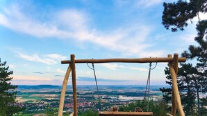 A wooden swing set with a bench, overlooking a town and fields. - Apartment 'Ferienwohnung Kammer' with Private Terrace, Shared Garden and Wi-Fi (Iphofen)