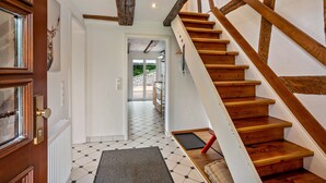 Un escalier avec des marches en bois et un mur blanc.