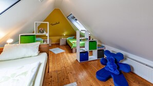 A triangular attic bedroom with a sloped ceiling, a bed, a desk, a chair, and a bookshelf. - Apartment 'Tulpe' with Balcony and Wi-Fi (Kalkar-Wissel)