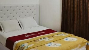 A bedroom with a bed, white headboard, and a window with curtains. - Hotel living international ltd (Dhaka)