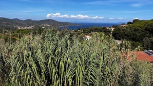 Un paisaje costero con vista al mar, montañas y un pueblo a lo lejos.