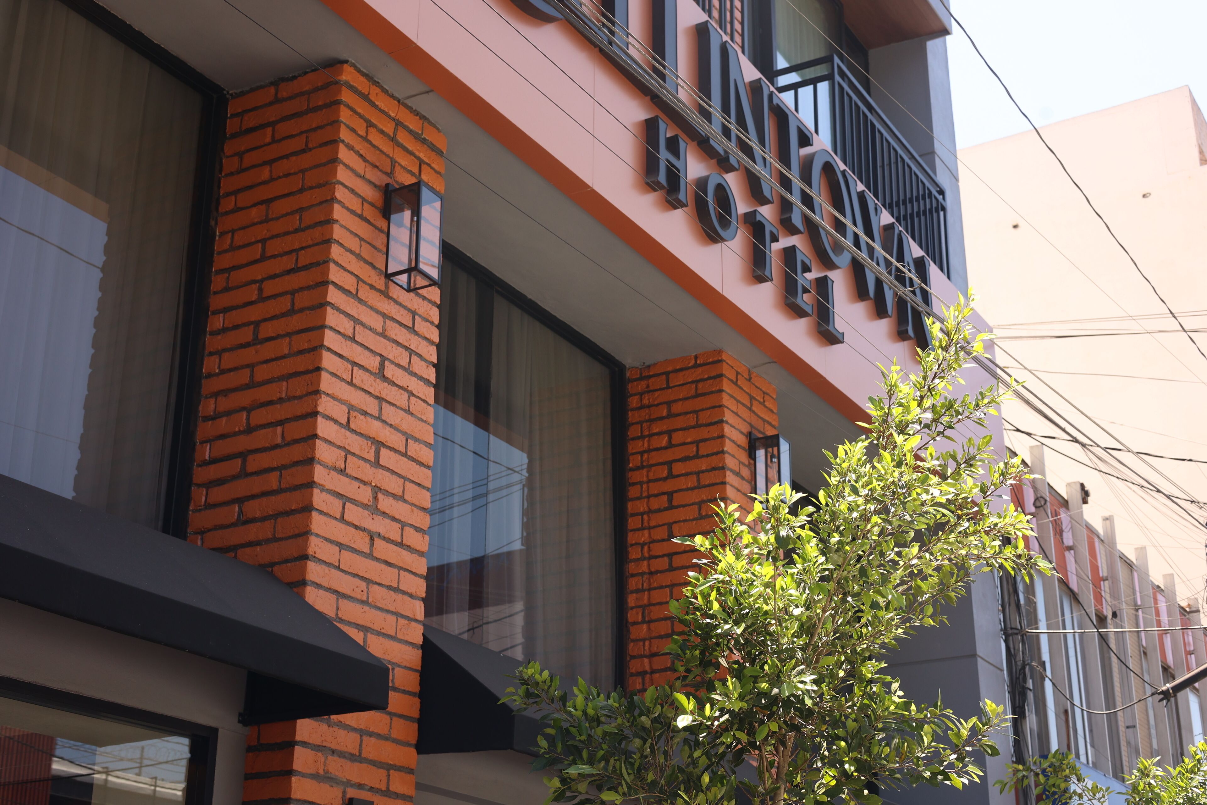 A hotel with a modern brick facade, large windows, and a visible balcony.