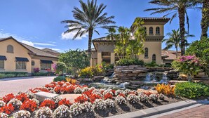 A hotel with a landscaped garden, a waterfall, and palm trees. - Naples Resort Condo on 2 Championship Golf Courses (Naples)