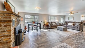 Ein geräumiges Wohnzimmer mit Kamin, Essbereich und einer Sofagarnitur.