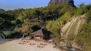 A beachside villa with a covered seating area, a pool, and a waterfall. - Villa Angelina Luxury Suites (Dapitan)