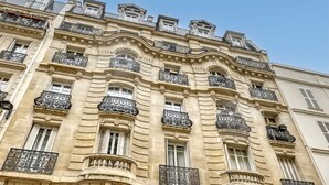 Un edificio de varios pisos con balcones ornamentados y arquitectura clásica.