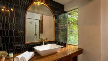 A modern bathroom with a large mirror, a wooden vanity, and a white vessel sink.