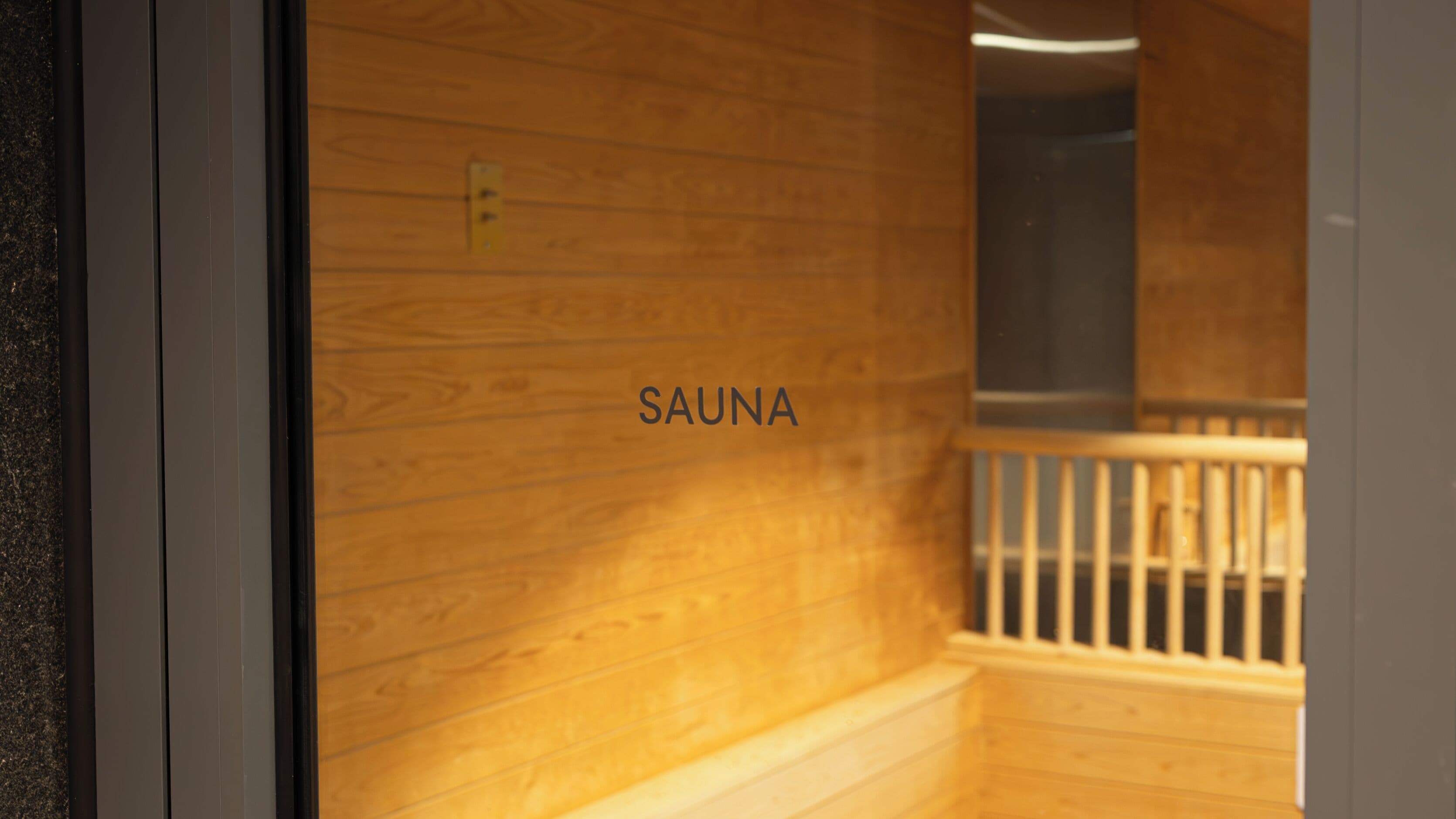 Een houten interieur met een bord waarop 'SAUNA' staat.
