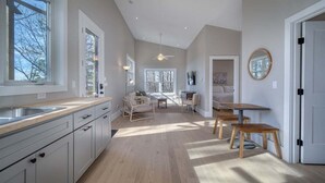Una cocina amplia con un ventanal grande, una zona de comedor con mesa y sillas, y un ventilador de techo.